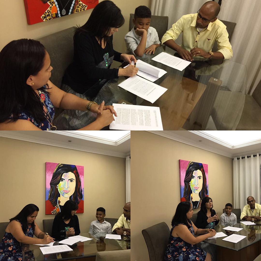 Fernanda Brum assinando contrato com kaiky Mello na presença dos pais do artista