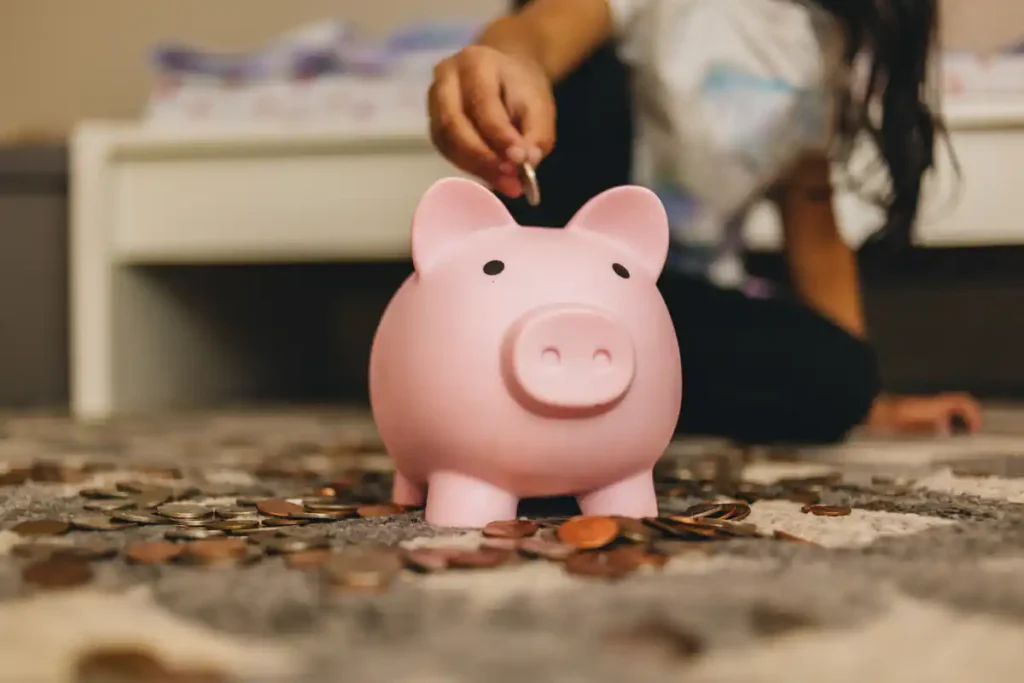 Criança colocando dinheiro eem cofre - @Reprodução