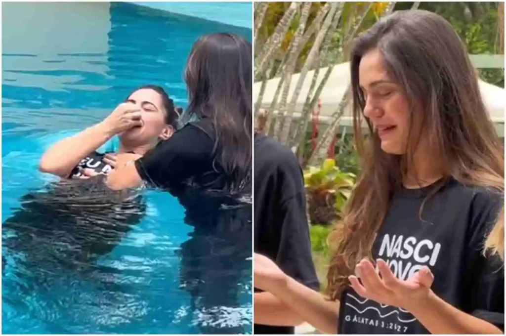 Atriz sendo batizada por imersão em piscina, emocionada, vestindo camiseta com frase bíblica, durante cerimônia evangélica ao ar livre.