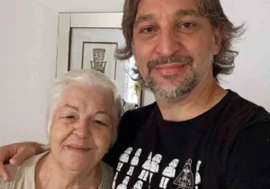 Cantor PG abraçado com sua mãe em casa, sorrindo em foto descontraída.