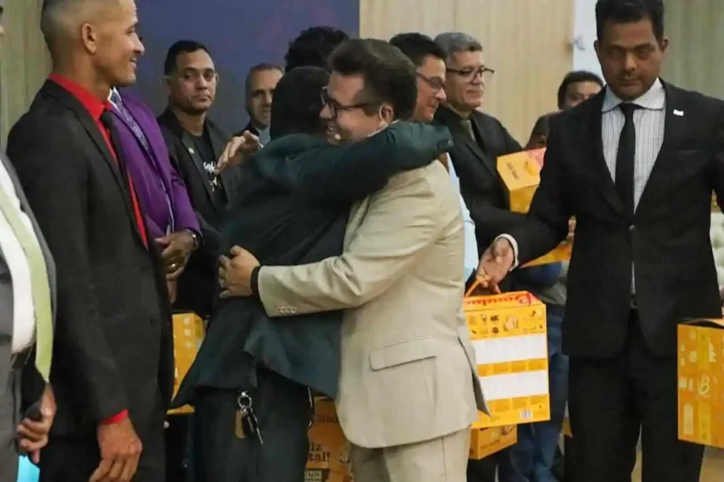 Pastor Jacques Balbino abraça líder religioso durante cerimônia cristã com entrega de doações em evento da igreja.