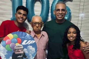 Pastor Júnior Trovão posa sorridente ao lado do pai e dos filhos em festa com tema do filme Up.