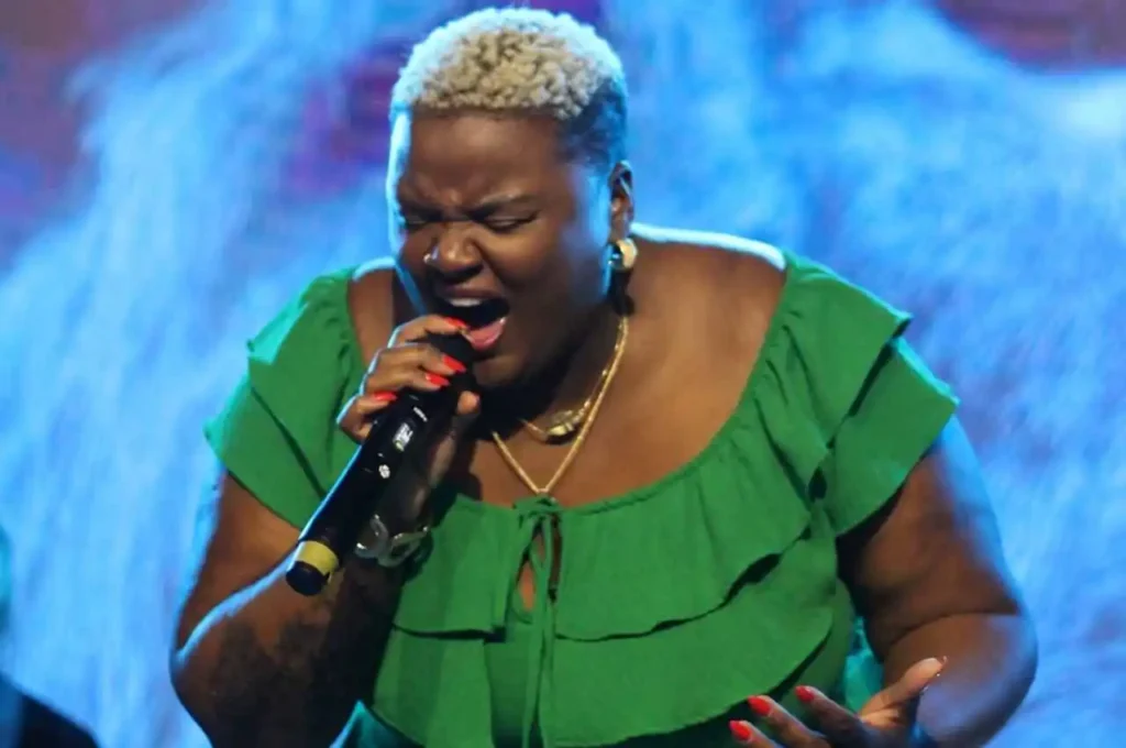 Cantora gospel Thayná cantando com intensidade e emoção durante apresentação ao vivo em evento cristão.