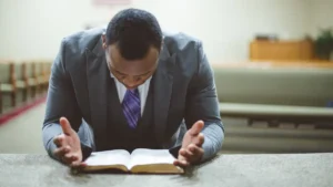homem orando com a biblia aberta em igreja durante momento de oracao e reflexao espiritual
