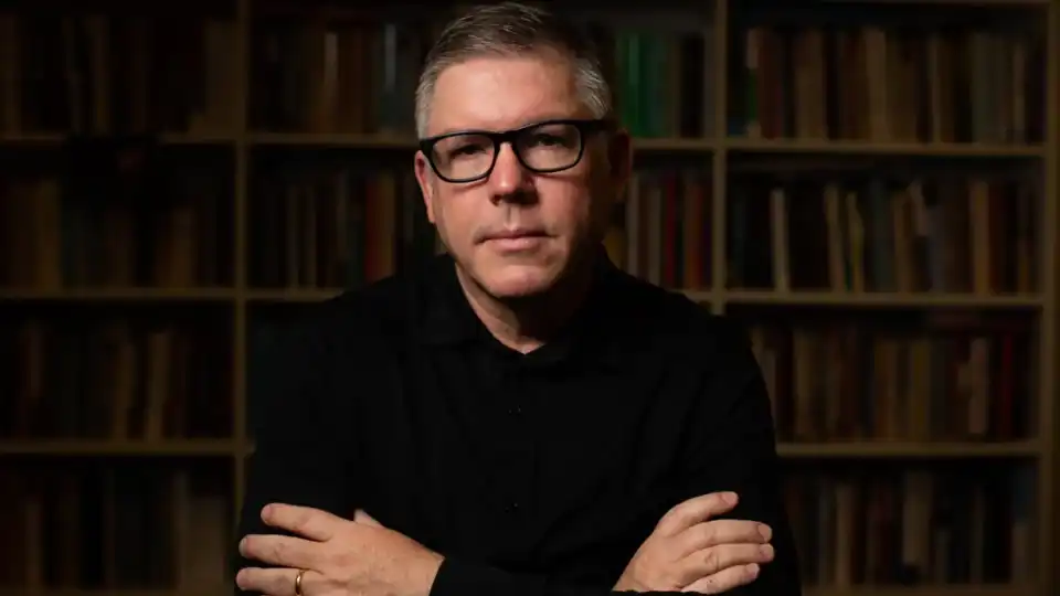 Pastor Ed René Kivitz posa para retrato com braços cruzados diante de estante de livros, imagem usada em matéria sobre consumo de bebida alcoólica por evangélicos