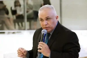 Pastor Ezequias Silva fala ao microfone durante evento em ambiente interno