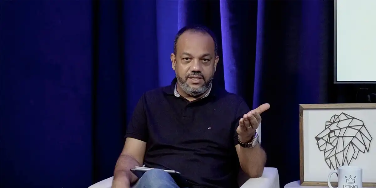 Pastor Rodrigo Gomes, líder do MEVAM Rio, sentado em poltrona durante gravação em estúdio, fala e faz gesto com a mão