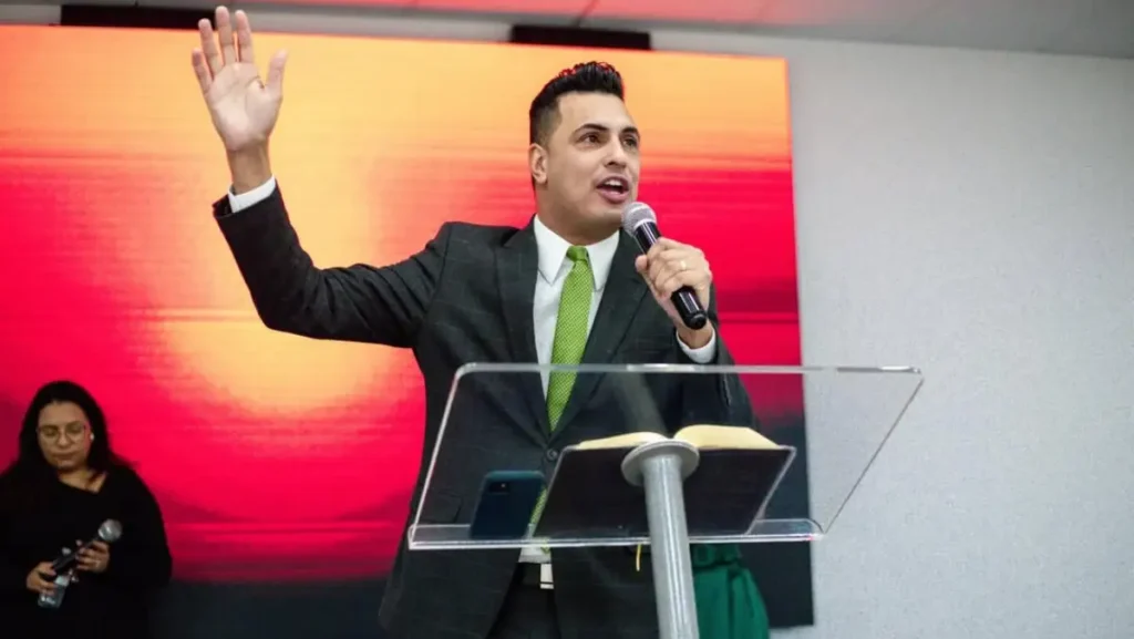pastor stevan bezerra discursando ao microfone durante culto da ad madureira portugal