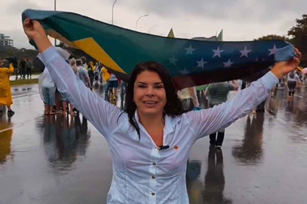 Mara Maravilha segurando bandeira do Brasil durante manifestação em via pública.