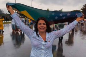 Mara Maravilha segurando bandeira do Brasil durante manifestação em via pública.