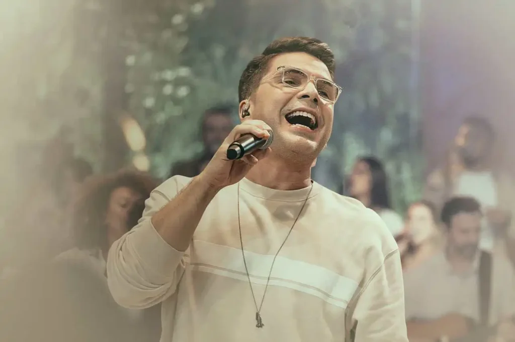 Cantor Paulo César Baruk cantando com expressão intensa durante apresentação de louvor em evento gospel ao vivo.