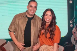 Cantor gospel Waguinho posa ao lado da esposa Fabíola durante evento musical cristão, sorrindo para a câmera.