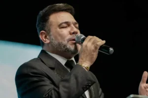 Pastor Marco Feliciano ministrando com olhos fechados e expressão de concentração durante culto evangélico no púlpito.