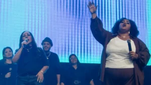 Chris Soares canta no palco com microfone durante gravação do primeiro DVD pela Track 3 Music ao lado de Rose Nascimento em participação especial