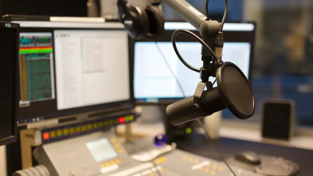 estúdio da Rádio Novas de Paz com microfone profissional e mesa de som em ambiente de transmissão