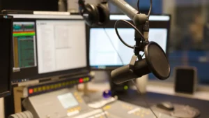 estúdio da Rádio Novas de Paz com microfone profissional e mesa de som em ambiente de transmissão