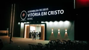 fachada iluminada do templo da Assembleia de Deus Vitória em Cristo (ADVEC) à noite durante inauguração com pessoas na entrada