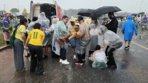 Marco Feliciano e equipe socorrem pessoa ferida na chuva após queda de raio em Brasília ao lado de ambulância