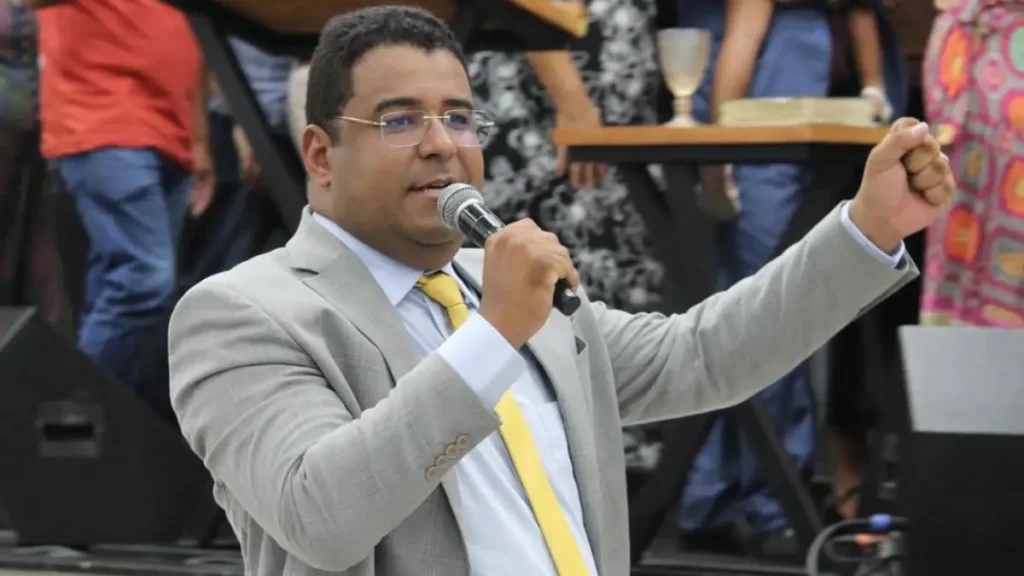 Pastor Jonatas Lins discursando ao microfone durante evento da Rede Esperança