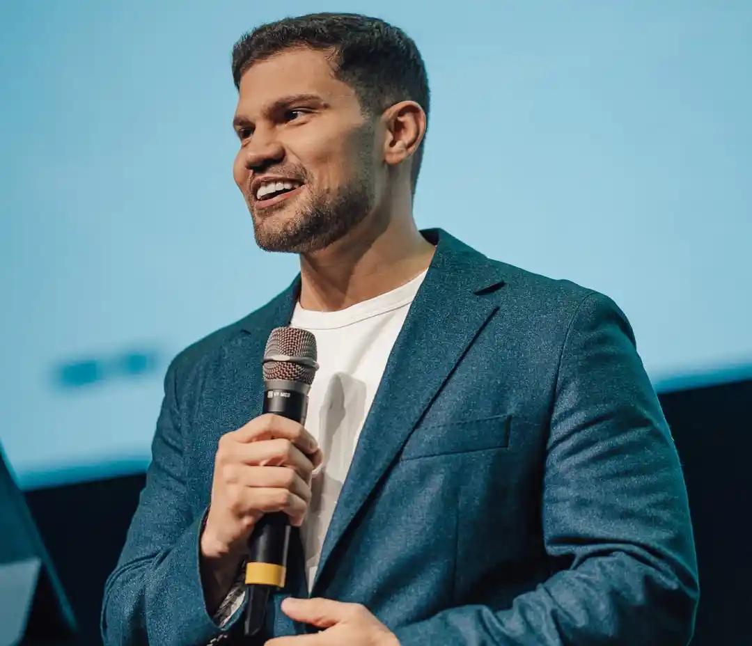 Pastor Lucas Torres, líder da Get Church, segura microfone e fala durante evento em palco