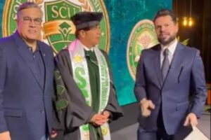 Apóstolo Agenor Duque usando beca e estola acadêmica durante cerimônia religiosa, ao lado de líderes evangélicos em evento institucional.