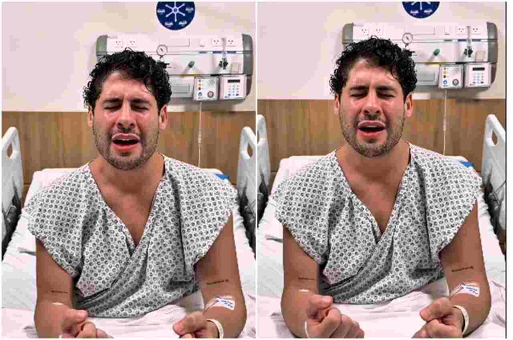 Cantor gospel Marcos Freire sentado em leito hospitalar, vestindo roupa de paciente, com os olhos fechados e expressão de oração