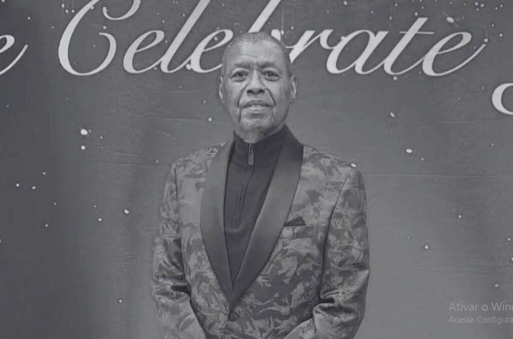 Ron Kenoly posando para foto oficial em evento, usando terno estampado, com expressão serena.