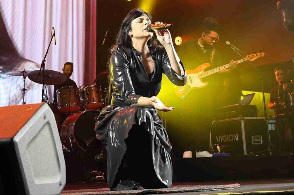 Fernanda Brum cantando ajoelhada no palco durante show