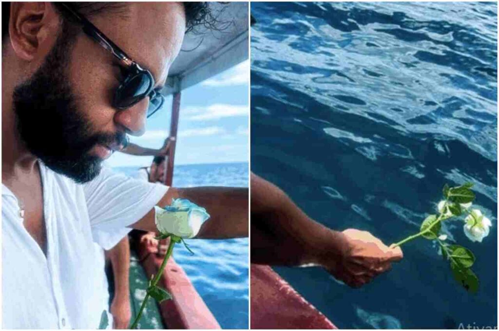 Henrique Vieira segura uma rosa branca e a lança ao mar durante ato simbólico em embarcação.