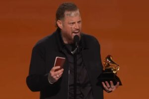 Jelly Roll discursando emocionado ao segurar troféu do Grammy durante cerimônia de premiação musical.