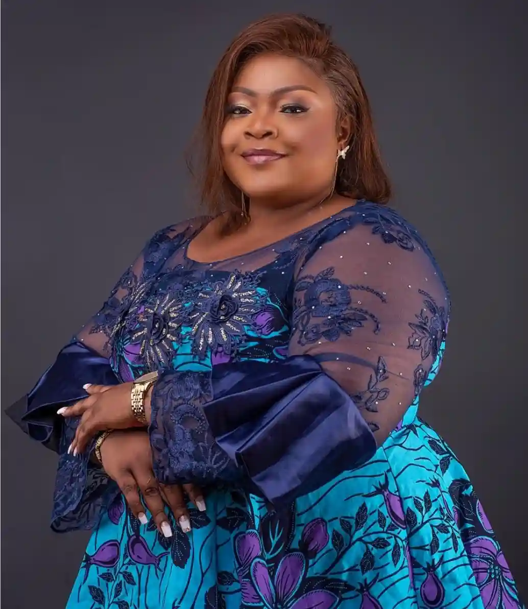 Cantora gospel Eunice Manyanga posa para retrato em estúdio, usando vestido azul com detalhes em renda