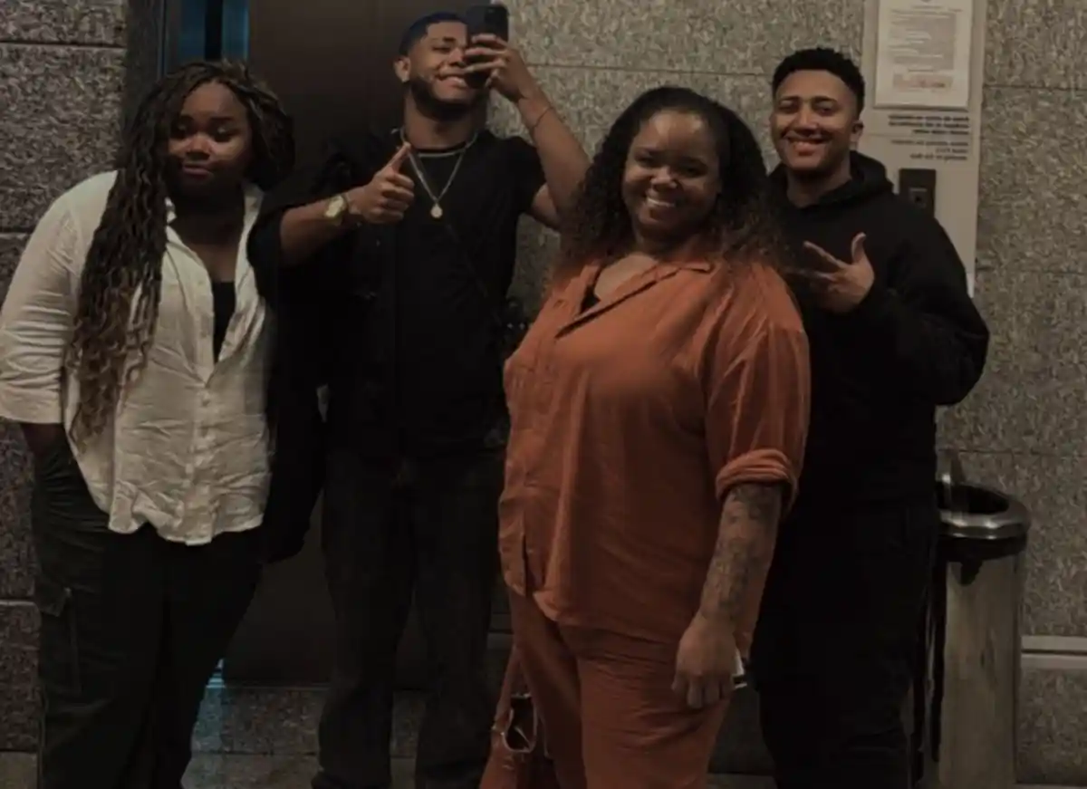 cantora gospel Kellen Byanca posa com três pessoas em selfie no espelho de hall com elevador