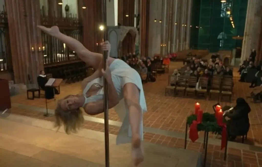 Mulher faz pole dance durante apresentação dentro de uma igreja na Alemanha, com fiéis sentados ao fundo