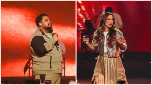 Lukas Agustinho canta com microfone no palco iluminado em vermelho enquanto Valesca Maysa se apresenta ao lado durante show