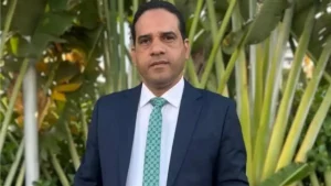 pastor eliu pacheco da assembleia de deus em pernambuco posa de terno ao ar livre diante de folhagens