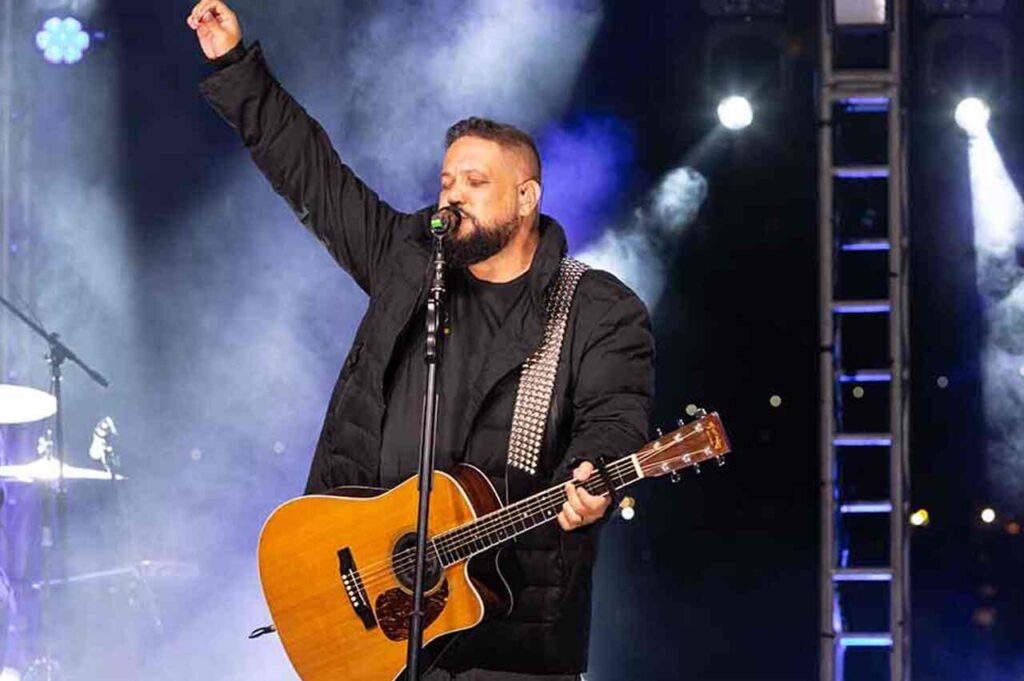 Cantor gospel Fernandinho cantando e tocando violão durante apresentação