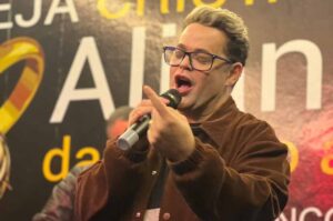 Cantor Robinson Monteiro cantando ao microfone durante apresentação