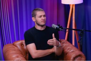 Júlio Ribeiro durante entrevista em podcast, falando ao microfone em estúdio.