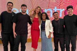 Cantora gospel Kemilly Santos posa com banda durante participação em programa da TV Globo.