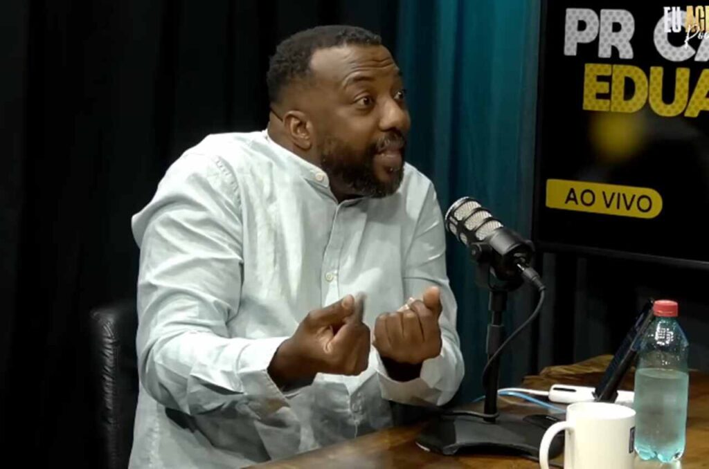 Pastor Carlos Eduardo falando ao microfone durante entrevista em podcast
