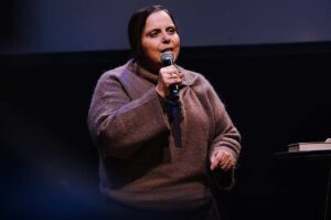 Pastora Helena Raquel ministrando ao microfone durante pregação em evento cristão.