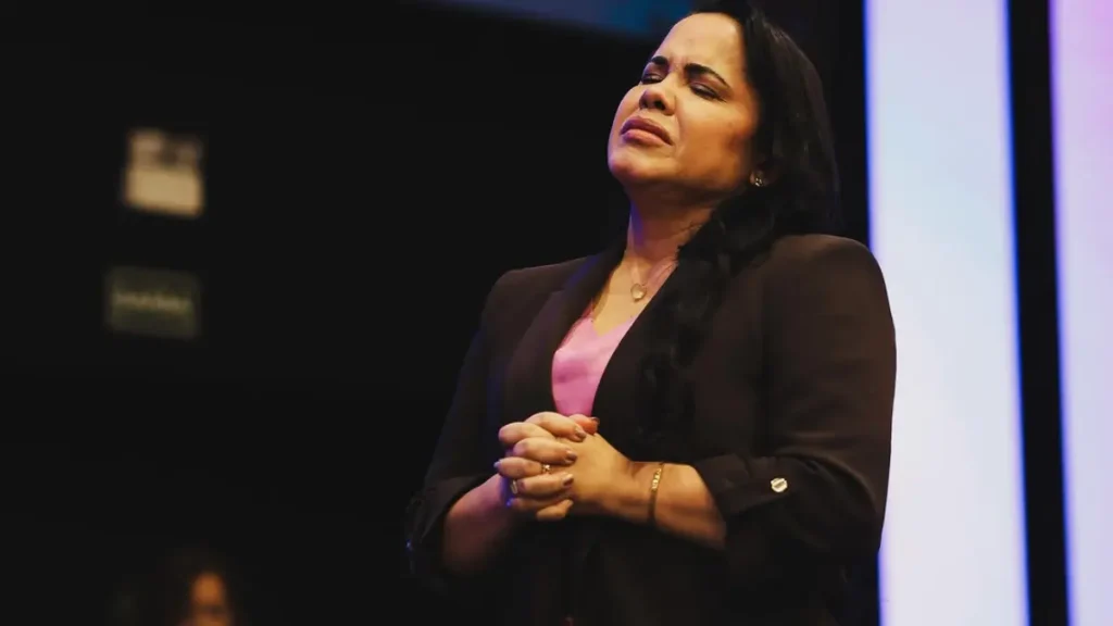 Cassiane aparece de olhos fechados e mãos unidas durante ministração no palco