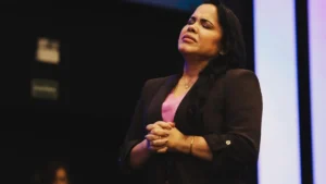 Cassiane aparece de olhos fechados e mãos unidas durante ministração no palco