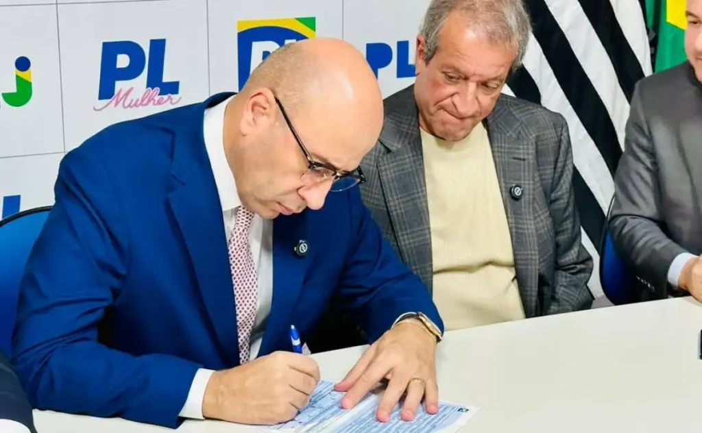 Pastor Oseias de Madureira observa Valdemar da Costa Neto assinando documento em evento do PL