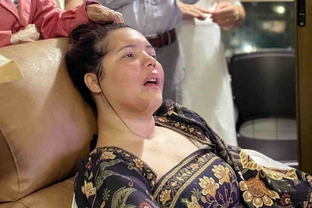 Amanda Wanessa aparece sentada enquanto recebe oração com imposição de mãos.