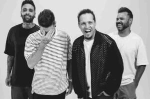 Banda Morada em ensaio fotográfico em preto e branco, com integrantes sorrindo e descontraídos.