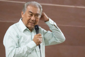 Isaac Sá segura microfone durante ministração, com a mão na cabeça.