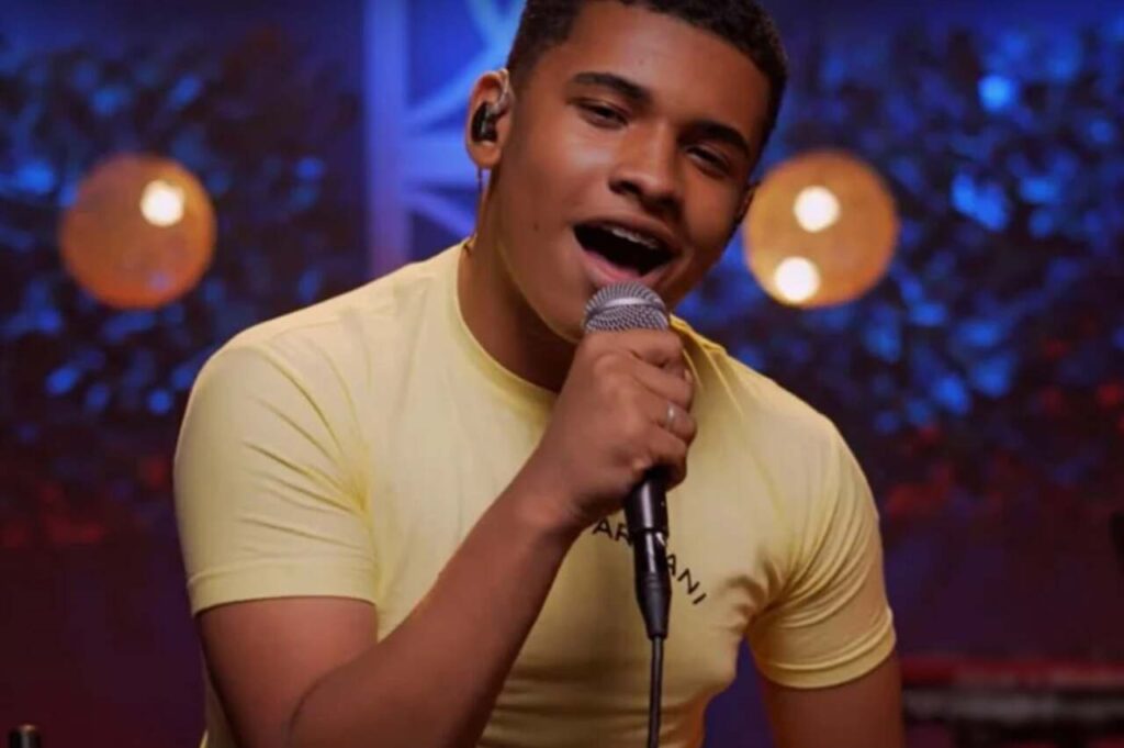 Cantor Kaiky Mello cantando ao microfone durante apresentação,
