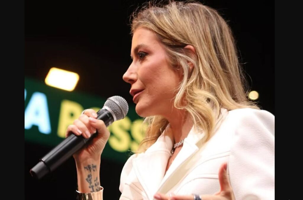 Luiza Possi canta ao microfone durante apresentação em palco.