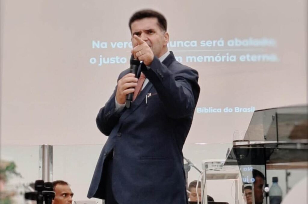 Pastor Edir Vinagre pregando em púlpito, apontando durante ministração com microfone.